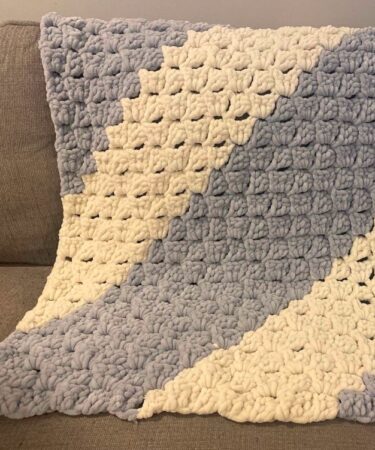Crochet chunky blanket pattern made with super bulky yarn, featuring a soft textured stitch design. Cozy handmade throw blanket crochet project with step-by-step instructions