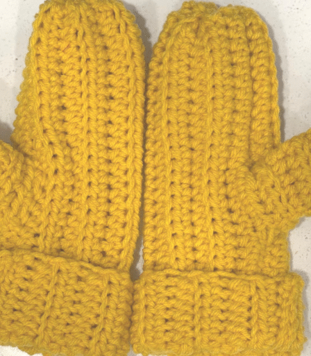 Handmade crochet ribbed mittens displayed flat, showing the textured ribbing pattern for an easy beginner crochet project with a free video tutorial, A pair of crochet ribbed mittens made with worsted weight yarn, promoting a simple beginner-friendly pattern with a free video tutorial. Crochet ribbed mittens in textured ribbing with easy beginner pattern and free video tutorial.